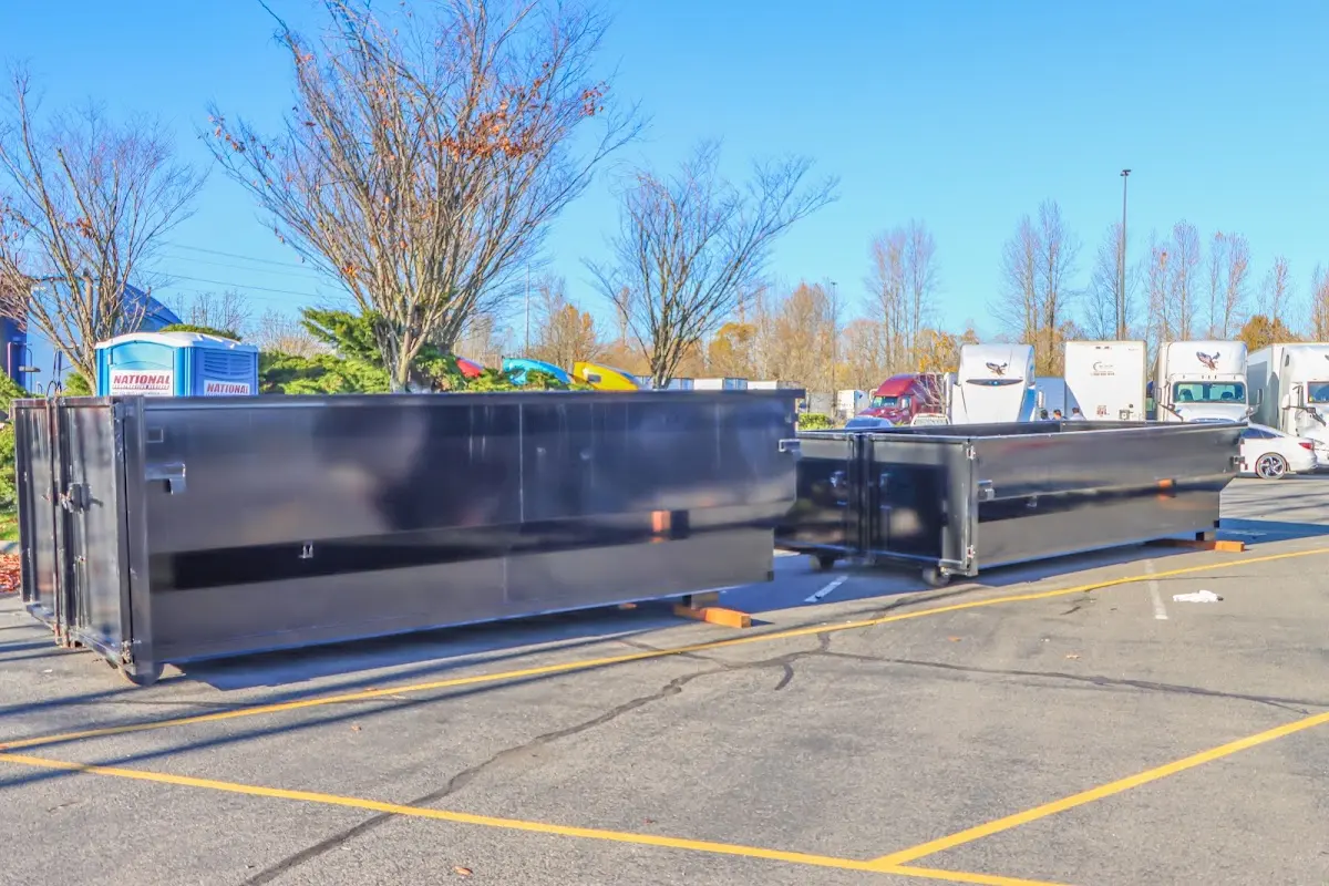 Professional dumpster rental service with roll-off container on residential driveway in Grand Forks